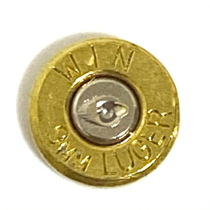 Polished brass slice of a 9mm Winchester Luger cartridge casing with a silver primer.