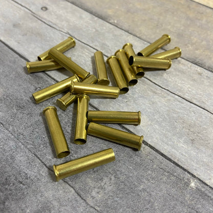 Scatter of polished .22 WMR brass casings resting on a weathered gray wood surface.