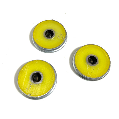 Three shotgun shell slices showing yellow hull coating around drilled brass centers
