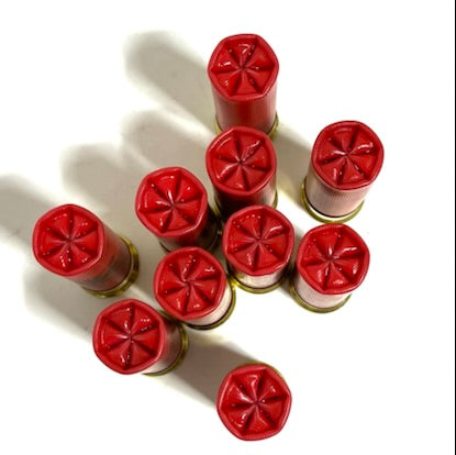 Direct overhead view of ten standing red Winchester Super X 12 gauge dummy rounds showing  a 6 star-crimped top mouths.