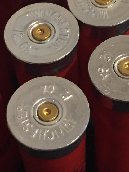 Close-up of silver Winchester 12 gauge headstamps on red shotgun shells