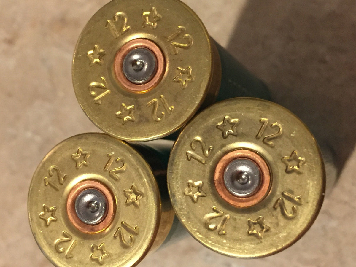 3 gold brass shell heads viewed close-up embossed "12" and star symbols