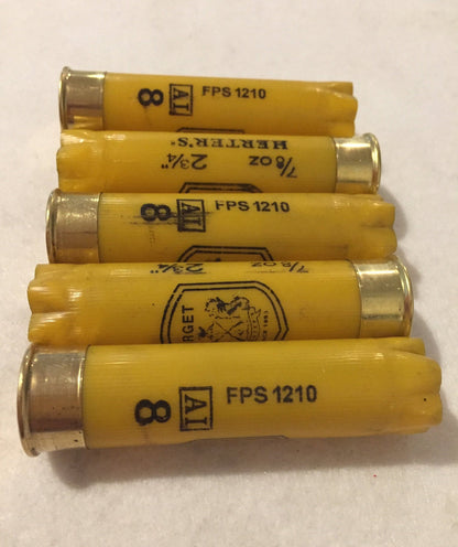 5 yellow shotgun shells viewed from above showing open mouths on a stone surface