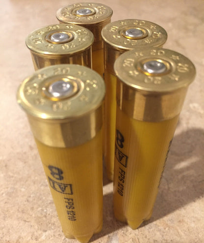 5 gold brass heads of yellow shotgun shells viewed from above showing 20 gauge markings