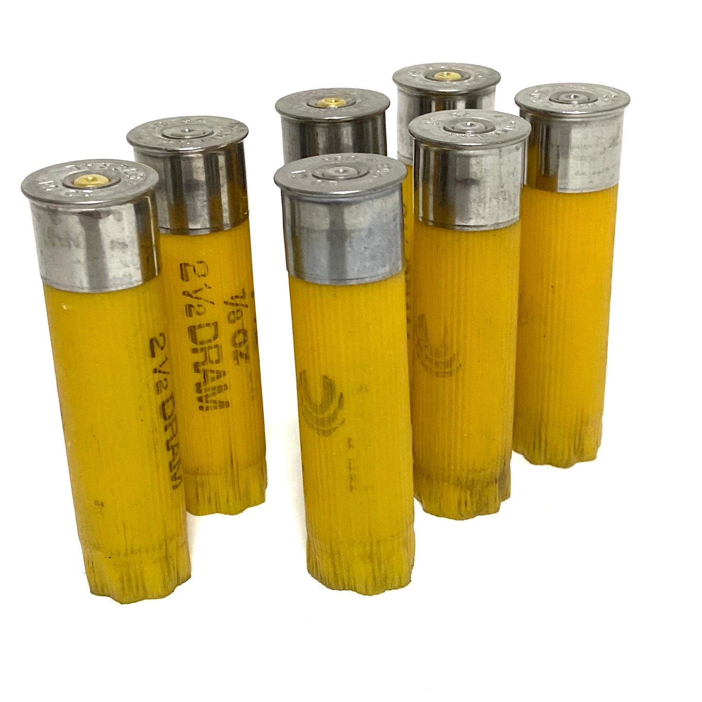 Six spent yellow 20 gauge shotgun shells standing upright on a white background showing silver bases and black hull printing.