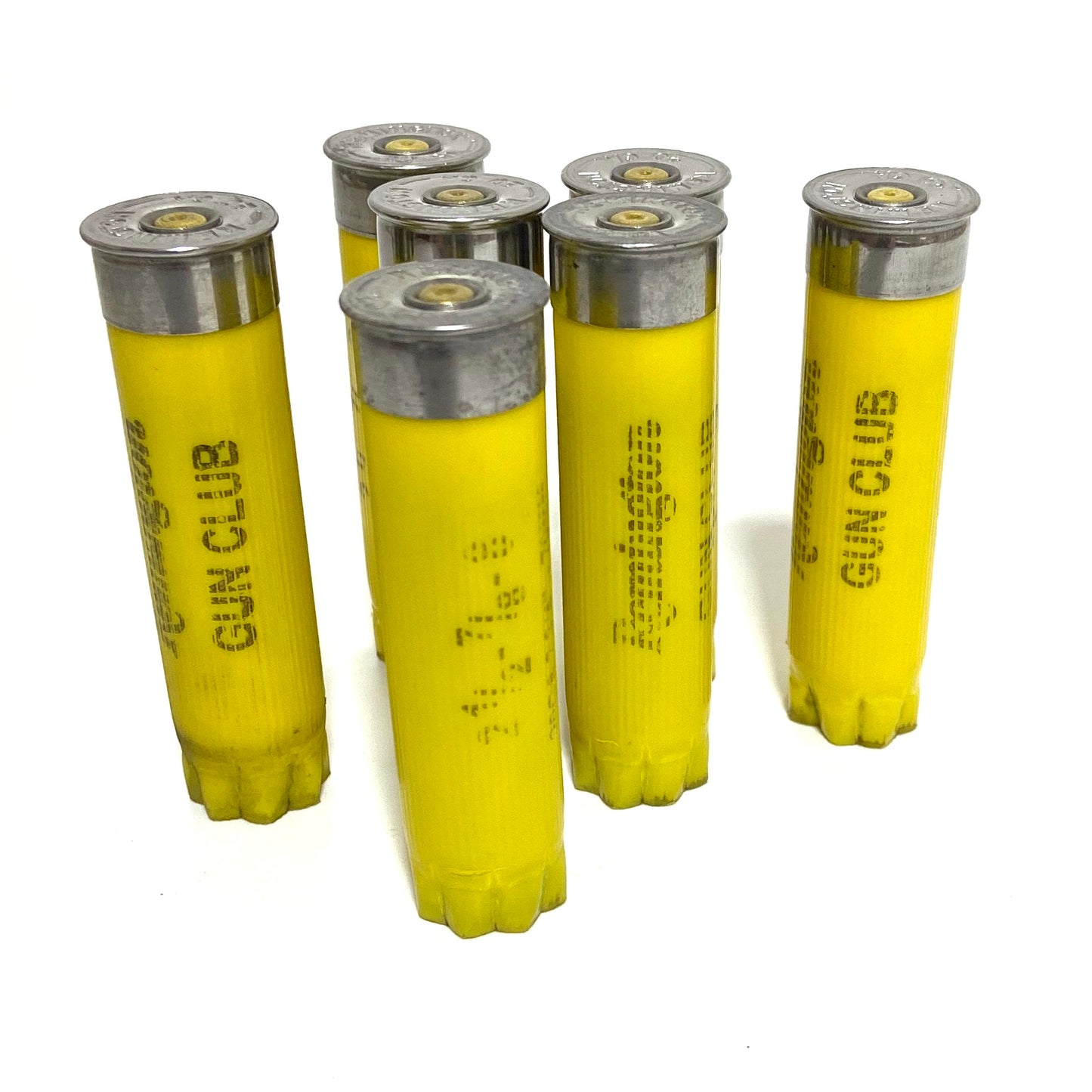 7 empty yellow shotshells standing upright, brass primers up, Gun Club text visible