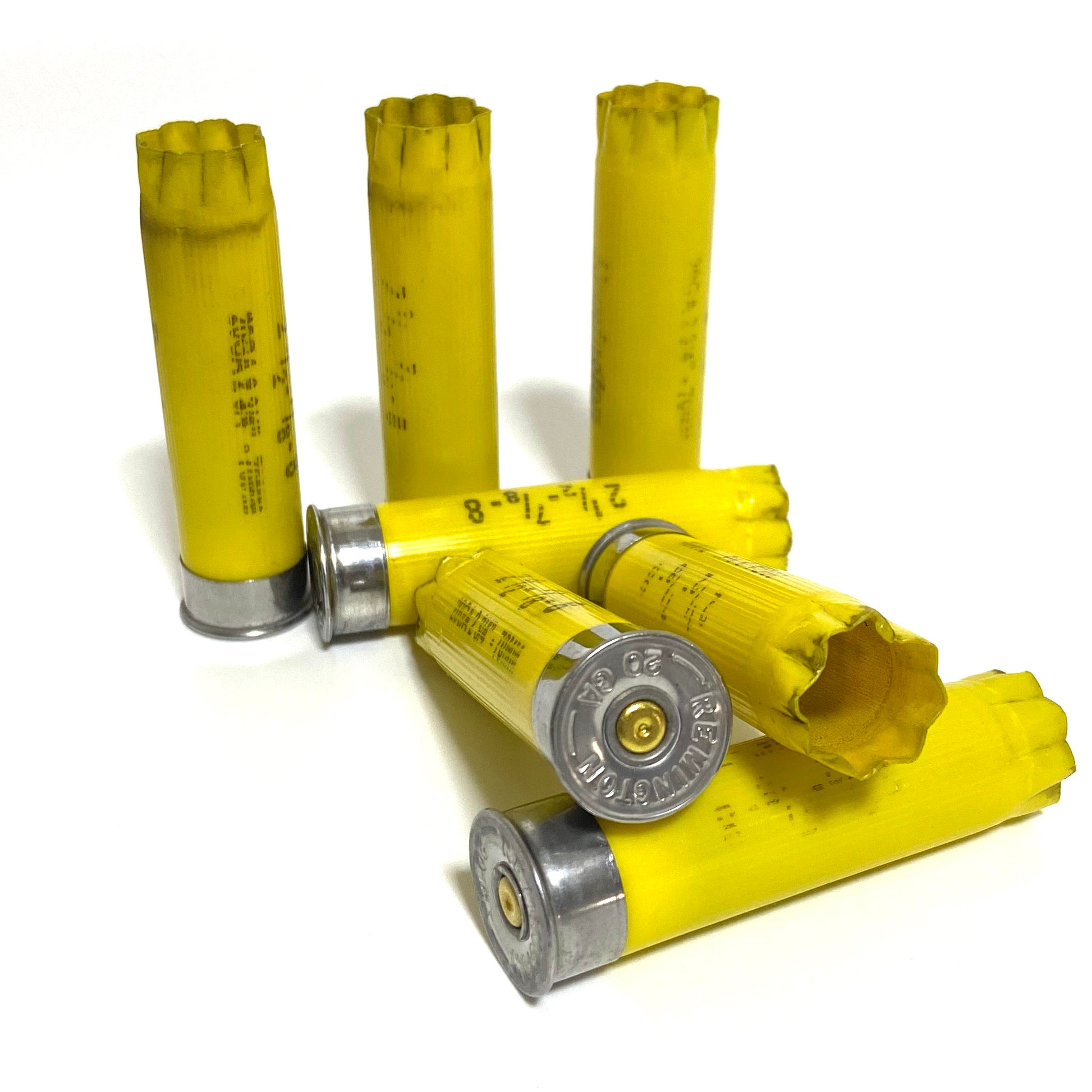 6 yellow once-fired 20-gauge hulls clustered together, one with a torn crimp