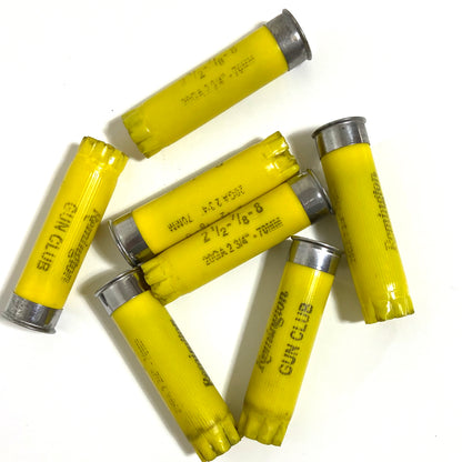 6 spent yellow cartridges arranged in a star pattern with Remington Gun Club markings